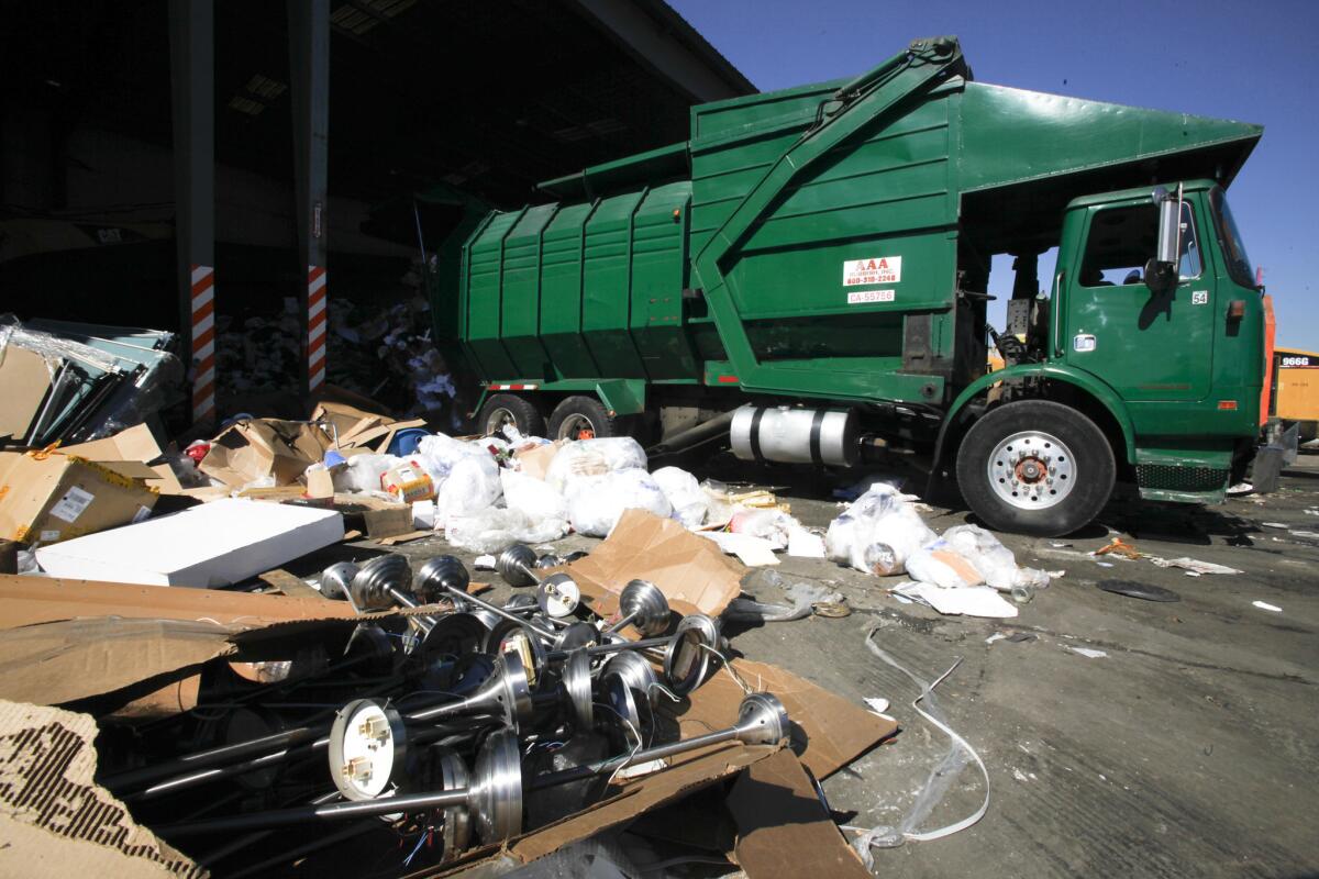 A truck with AAA Rubbish Inc. backs into a dumping spot at City Terrace Recycling in 2012.