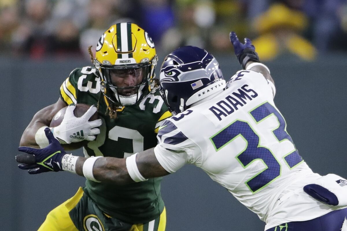 Green Bay Packers' Aaron Jones tries to get past Seattle Seahawks' Jamal Adams during the first half of an NFL football game Sunday, Nov. 14, 2021, in Green Bay, Wis. (AP Photo/Aaron Gash)