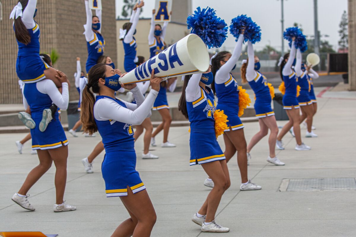 Cheerleaders perform a routine before class on the first day of school at Mira Mesa High School