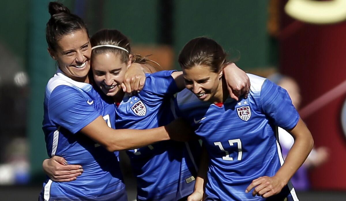 United States' Morgan Brian, center, is congratulated by teammates Ali Krieger, left, and Tobin Heath, after scoring during the second half of an exhibition soccer match against New Zealand on April 4. The trio are on the U.S. Women's World Cup roster, which Coach Jill Ellis announced on Tuesday.