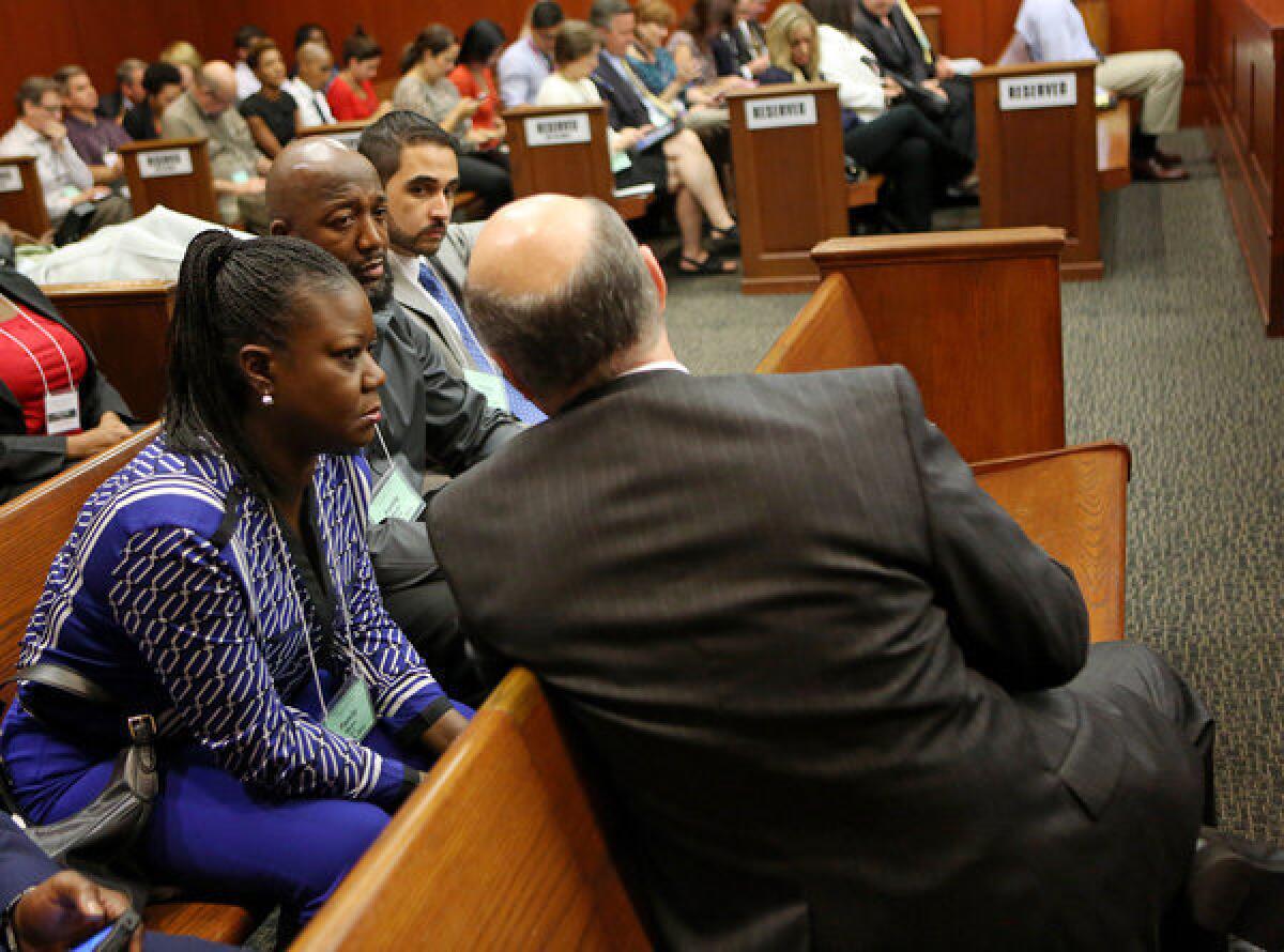 Assistant state attorney Bernie de la Rionda, with back to camera, speaks with Trayvon Martin's parents, Sybrina Fulton, left, and Tracy Martin, at the end of the lunch recess during George Zimmerman's trial in Sanford, Fla.