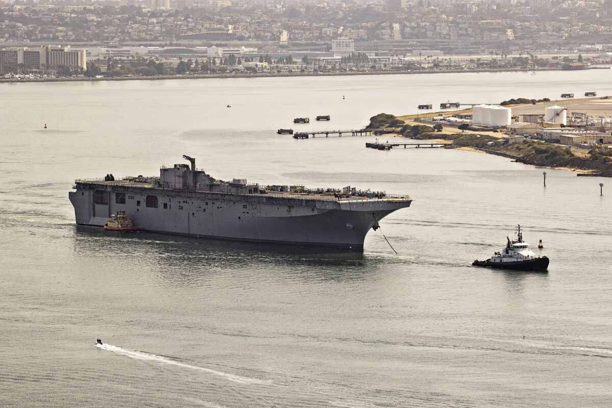 The hulk of the Bonhomme Richard is towed out of San Diego Bay on April 15, 2021