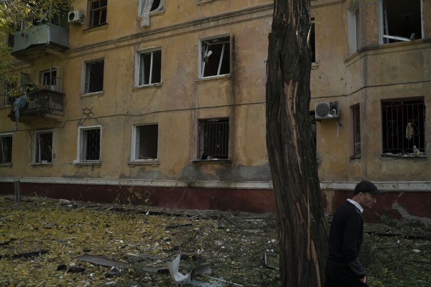 A man walks past a damaged building after a Russian attack in Kramatorsk, Ukraine, Thursday, Sept. 29, 2022. (AP Photo/Leo Correa)