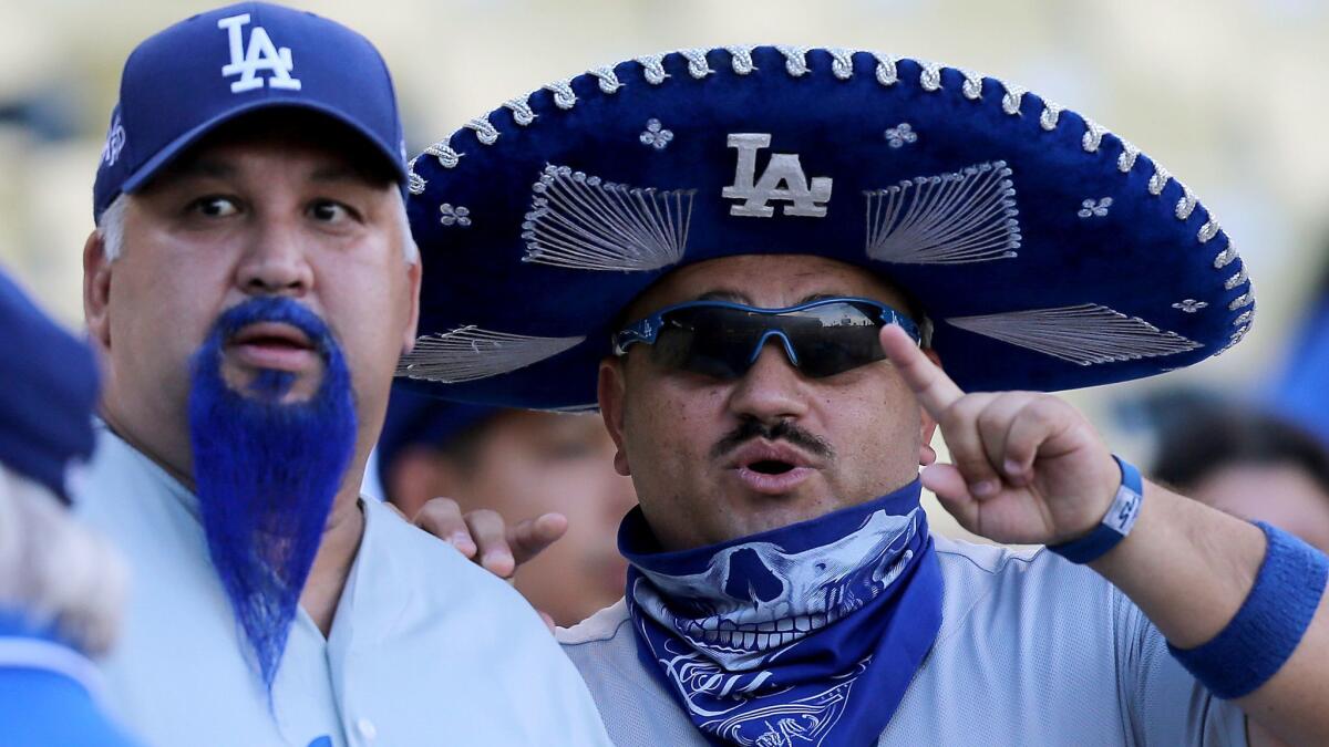 Dodgers fans “Blue Beard” and “Mariachi Loco” wait for the start of a rivalry game against the San Francisco Giants on Sept. 1, 2015, at Dodger Stadium in Los Angeles.