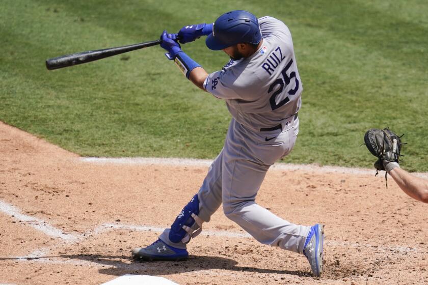 Los Angeles Dodgers Keibert Ruiz hits a solo home run during the third inning of a baseball game.