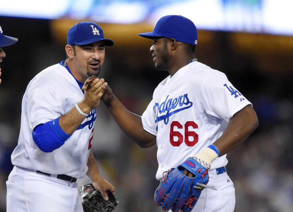 Los Angeles Dodgers' Adrian Gonzalez, left, and Yasiel Puig congratulate each other after the Dodgers defeated the Philadelphia Phillies 6-0 in a baseball game, Thursday, July 9, 2015, in Los Angeles. Both hit home runs in the game. (AP Photo/Mark J. Terrill)