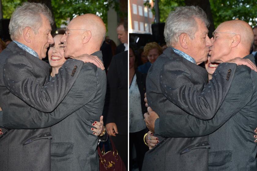 Actors Ian McKellen, left, and Patrick Stewart kiss at the U.K. premiere of "Mr. Holmes" in Kensington as Sunny Ozell, Stewart's wife, watches.