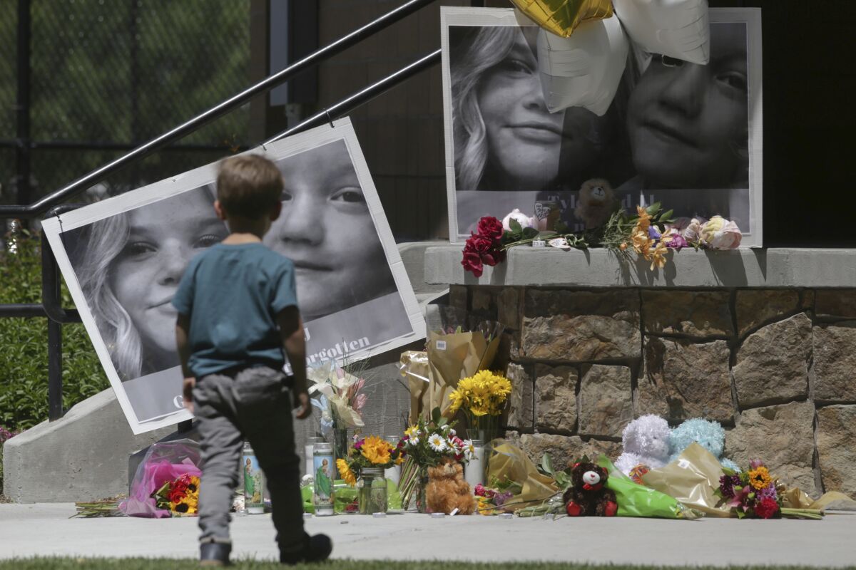 FILE - A boy looks at a memorial for Tylee Ryan and Joshua "JJ" Vallow in Rexburg, Idaho, on June 11, 2020. A mother charged with murder in the deaths of her two children is set to stand trial in Idaho. The proceedings against Lori Vallow Daybell beginning Monday, April 3, 2023, could reveal new details in the strange, doomsday-focused case. (John Roark/The Idaho Post-Register via AP, File)