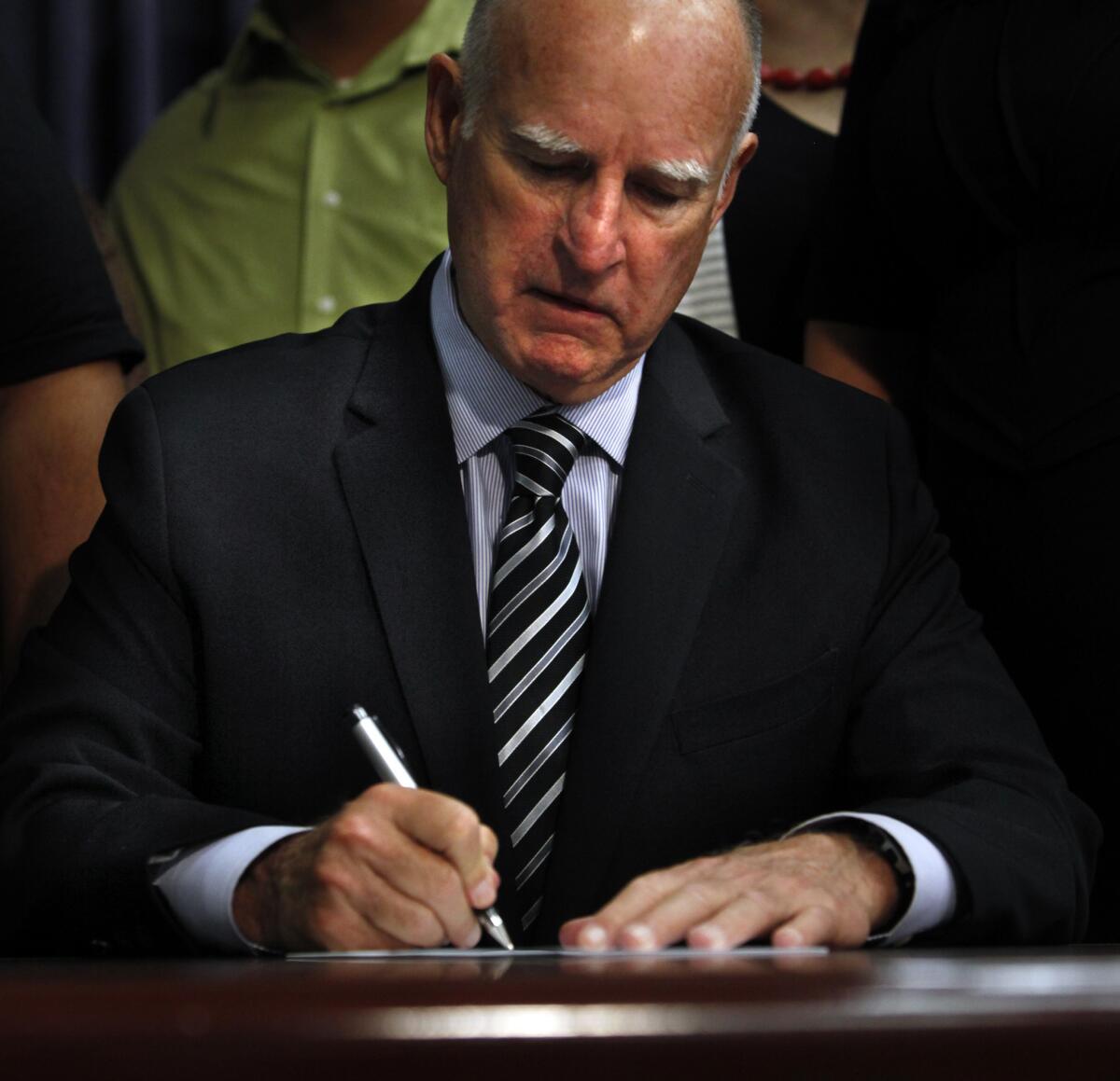 Gov. Jerry Brown signs legislation in Los Angeles on Sept. 10, 2014.