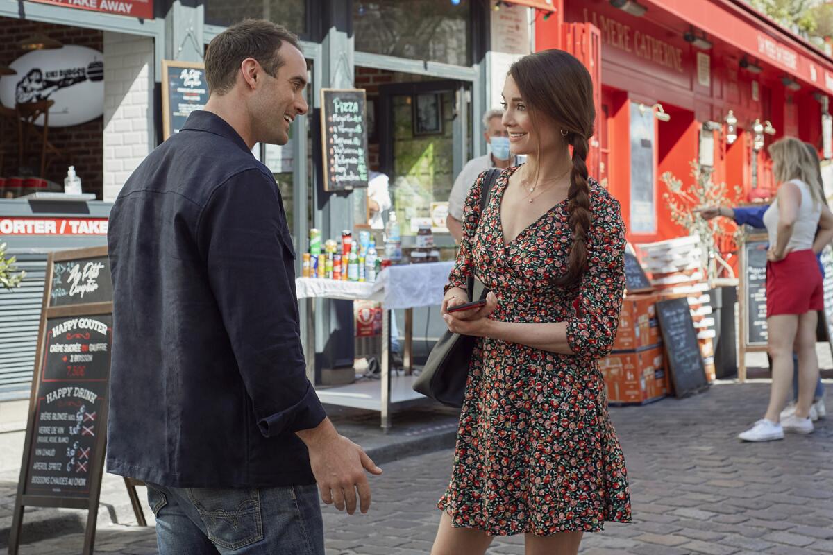 A man and a woman talk on a Paris street.