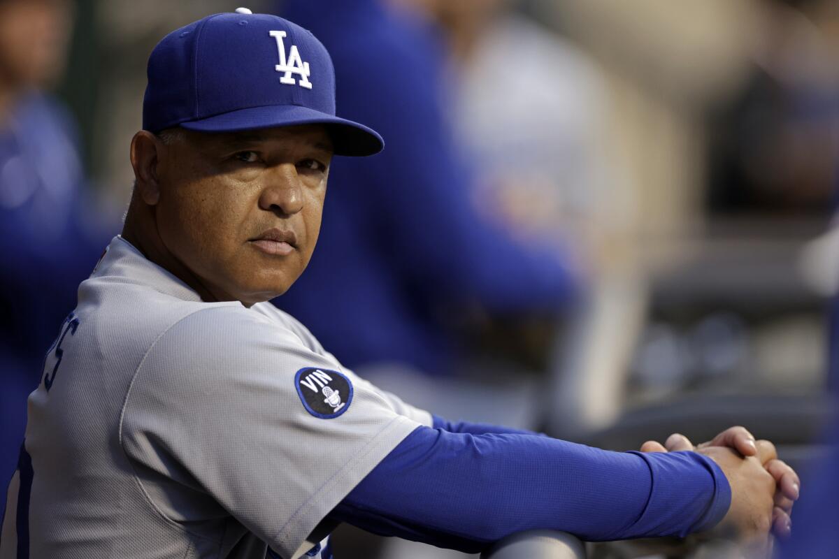 Los Angeles Dodgers manager Dave Roberts stands in the dugout before a game last season