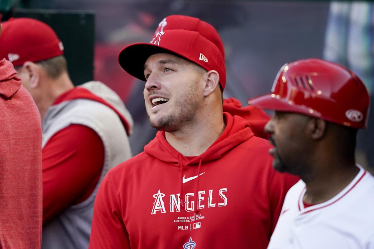 Angels center fielder Mike Trout speaks with teammates in the dugout.