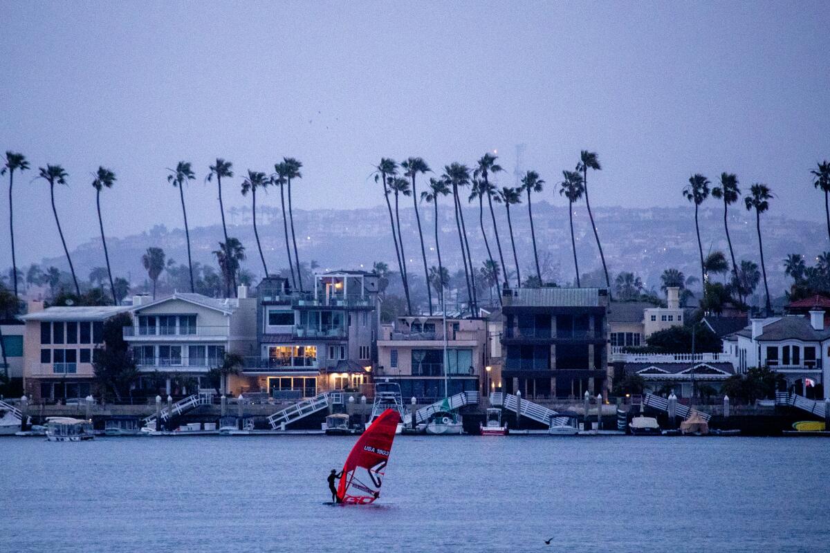 Long Beach, CA - February 21: A windsurfer takes advantage of cold, gusty winds kicking up as a winter storm approaches Southern California at dusk in Alamitos Bay in Long Beach Tuesday, Feb. 21, 2023. A winter storm warning remains in effect from 7pm Tuesday to 4 AM PST Saturday. Heavy snow is possible. Up to 1 foot of snow accumulation between 1,000 feet and 4,000 feet and 1 to 2 feet of snow accumulation above 4,000 feet. Winds could gust as high as 65 mph. (Allen J. Schaben / Los Angeles Times)
