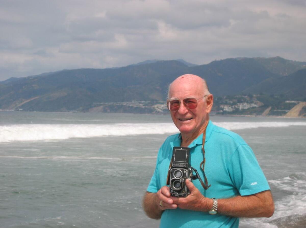 Bill Beebe holds a camera.