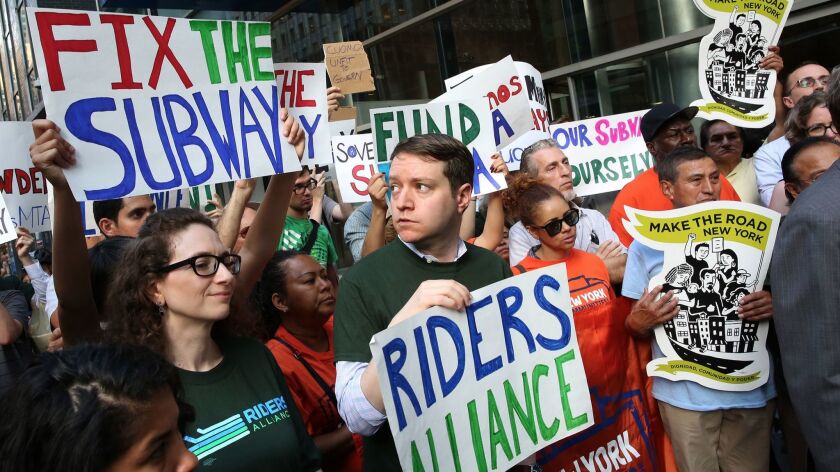John Raskin, center, executive director of Riders Alliance, leads a rally demanding improvements in New York public transportation.