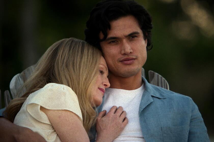 Julianne Moore as Gracie Atherton-Yoo snuggles on the shoulder and chest of Charles Melton as Joe in the film 'May December'