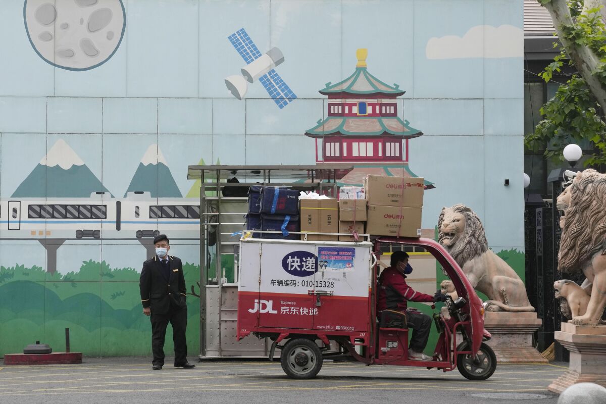 A delivery man past through the entrance to a community on Tuesday, May 10, 2022, in Beijing. China's capital began another round of three days of mass testing for millions of its residents Tuesday in a bid to prevent an outbreak from growing to Shanghai proportions. (AP Photo/Ng Han Guan)