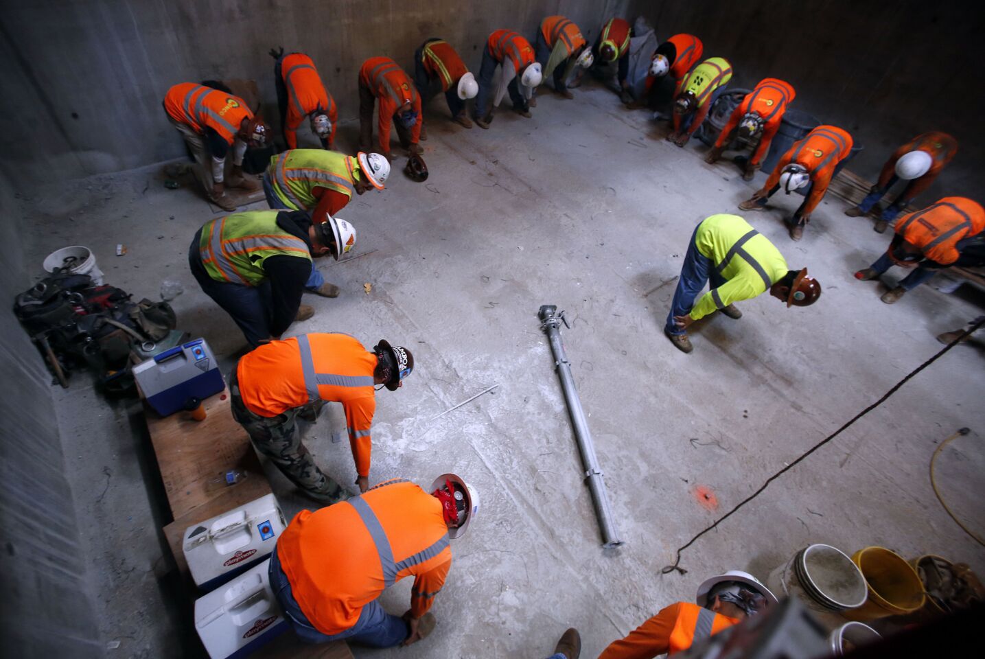 Carpenters do warmup exercises to loosen their muscles before starting their shift on the Wilshire Grand tower.
