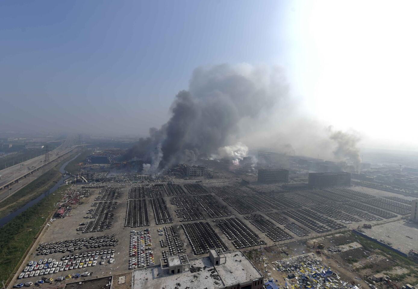 En esta imagen, distribuida por la agencia oficial de noticias china Xinhua, una columna de humo sale de la zona de almacenesl donde se registraron explosiones, en el noreste de la municipalidad de Tianjin, en China, el 13 de agosto de 2015.
