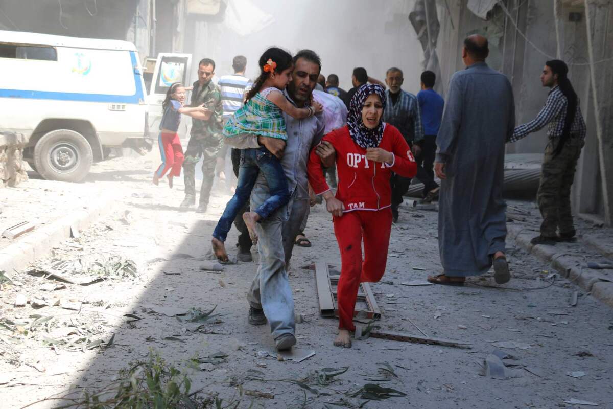 A family runs for cover amid the rubble of destroyed buildings after an airstrike on a rebel-held neighborhood in Aleppo, Syria, on April 29.