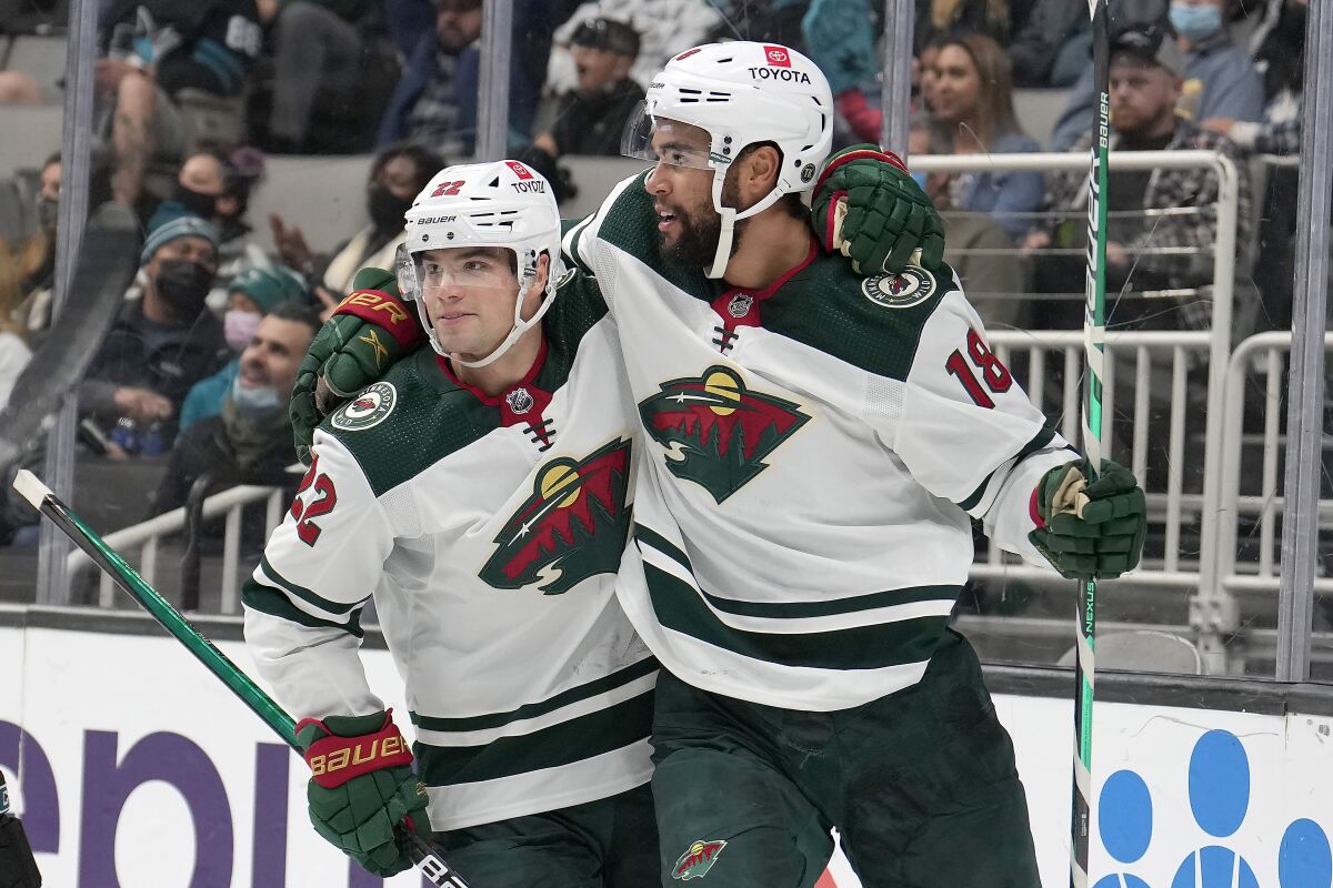 Minnesota Wild left wing Jordan Greenway (18) is congratulated by Kevin Fiala (22) after scoring a goal against the San Jose Sharks during the second period of an NHL hockey game Thursday, Dec. 9, 2021, in San Jose, Calif. (AP Photo/Tony Avelar)