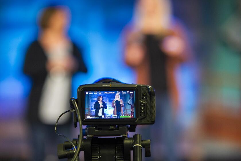 Diane Hodkin, left, and Jen Epperson both children's pastors from Mariners Church, film a family worship service at the Newport Beach church on Tuesday, March 17.