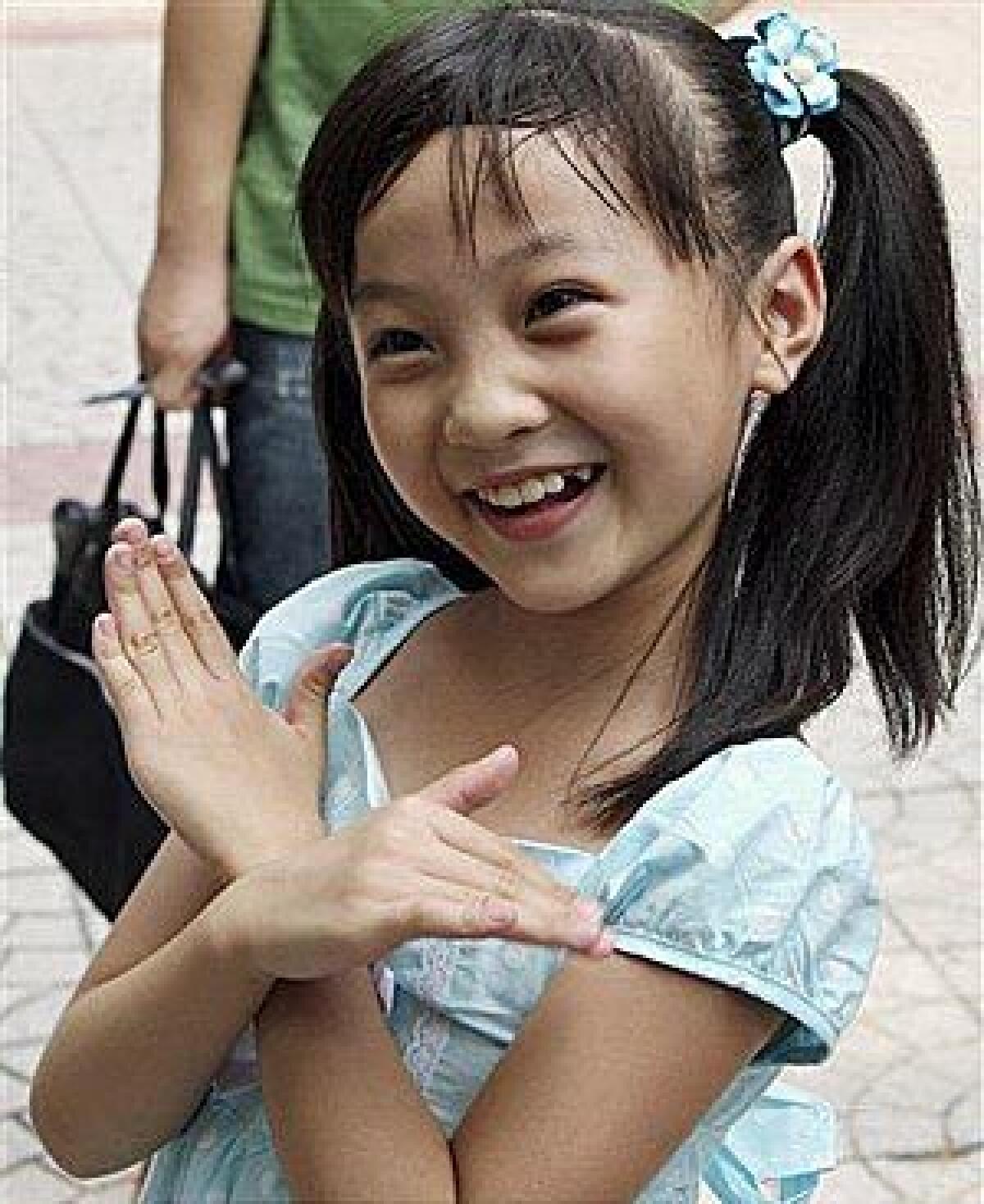 This photo released by China's Xinhua News Agency shows Lin Miaoke, a nine-year-old Chinese girl who performed at the opening ceremony of the Beijing Olympics. A 7-year-old Chinese girl's face was "not suitable" for the Olympics opening ceremony, so Lin lip-synched "Ode to the Motherland."