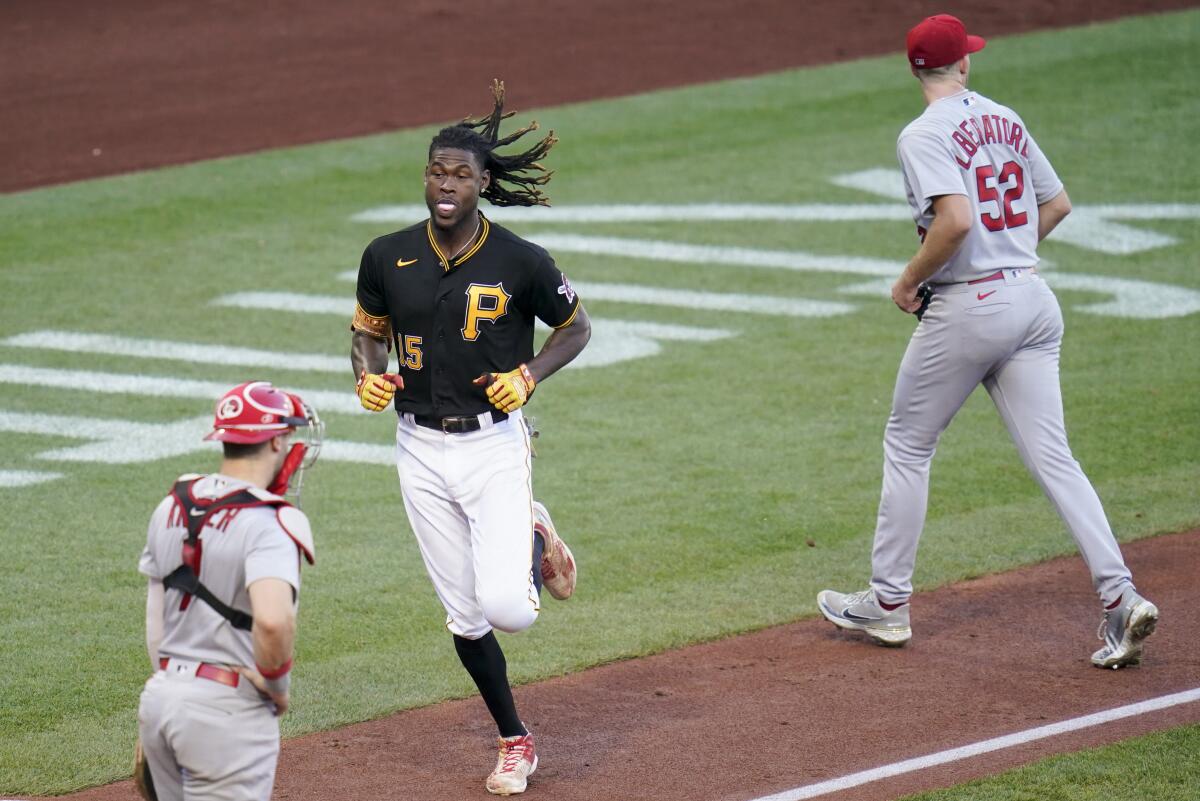 Pittsburgh Pirates' Oneil Cruz, center, heads home to score between St. Louis Cardinals starter Matthew Liberatore (52) and catcher Andrew Knizner, left, on a double by Diego Castillo during the fourth inning of a baseball game, Wednesday, Oct. 5, 2022, in Pittsburgh. (AP Photo/Keith Srakocic)