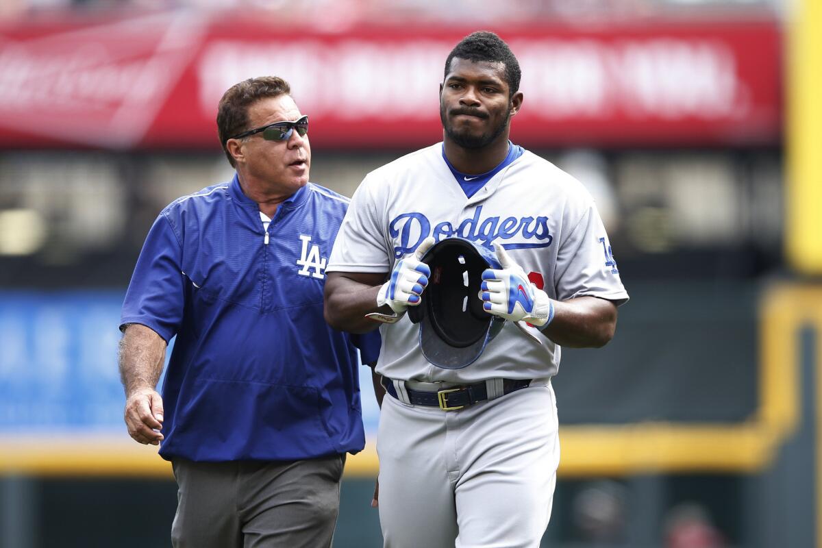 Yasiel Puig leaves the field after suffering a hamstring injury while trying to beat out a throw to first base in the ninth inning of a game against the Reds on Aug. 27.