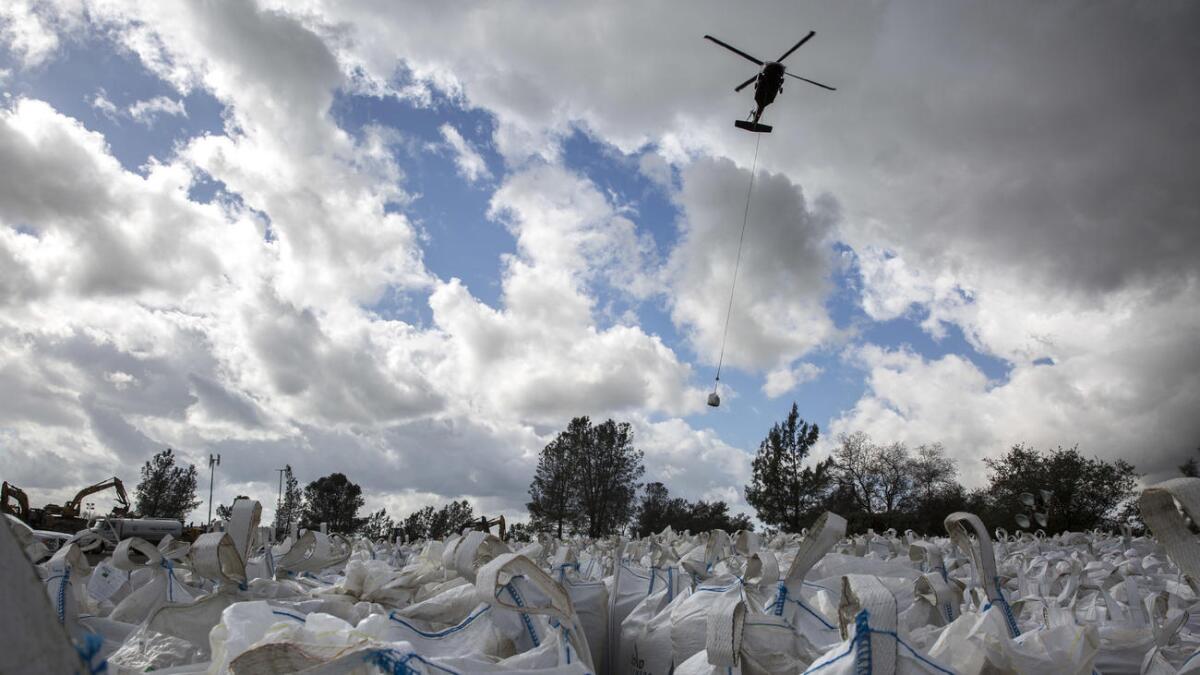 Helicopters ferry sand and rocks from a staging area to the Oroville Dam's emergency spillway repair project.