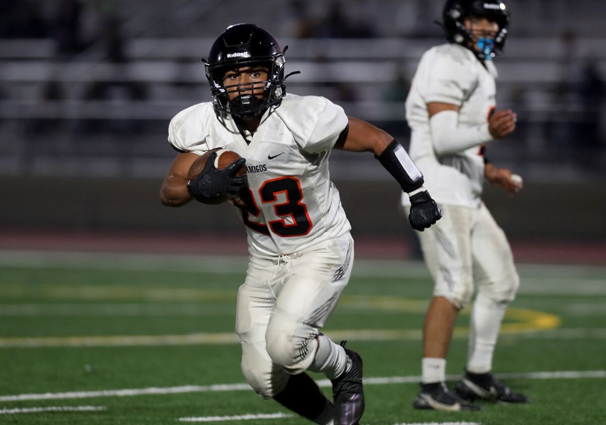 Los Amigos' Pedro Hernandez carries the ball against Rancho Alamitos during the first half at Bolsa Grande High on Thursday.