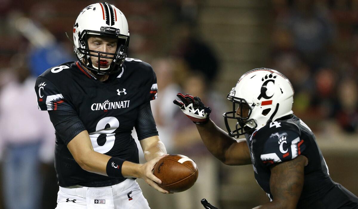 Cincinnati quarterback Hayden Moore (8) hands-off to running back Hosey Williams (4) during the second half of a game against Alabama A&M on Sept. 5.