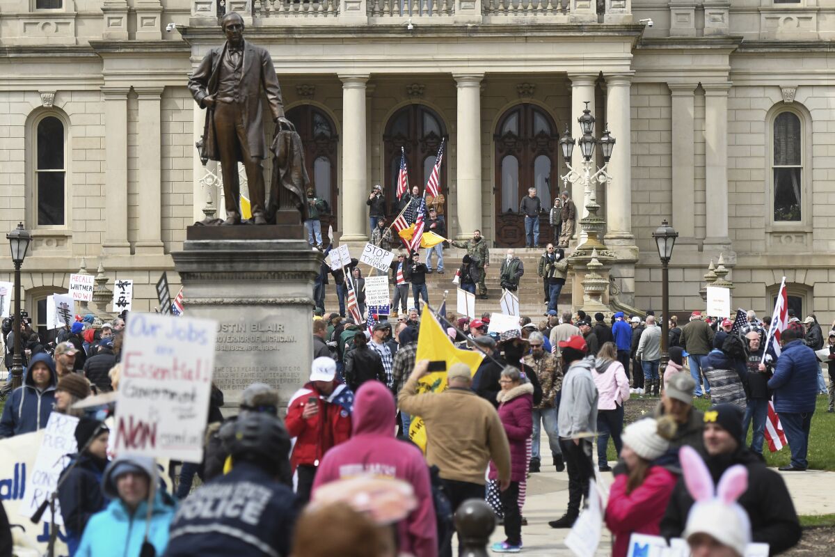 People protest against Michigan Gov. Gretchen Whitmer's stay-at-home order due to the coronavirus outbreak Wednesday, April 15, 2020, in downtown Lansing, Mich. at the State Capitol.