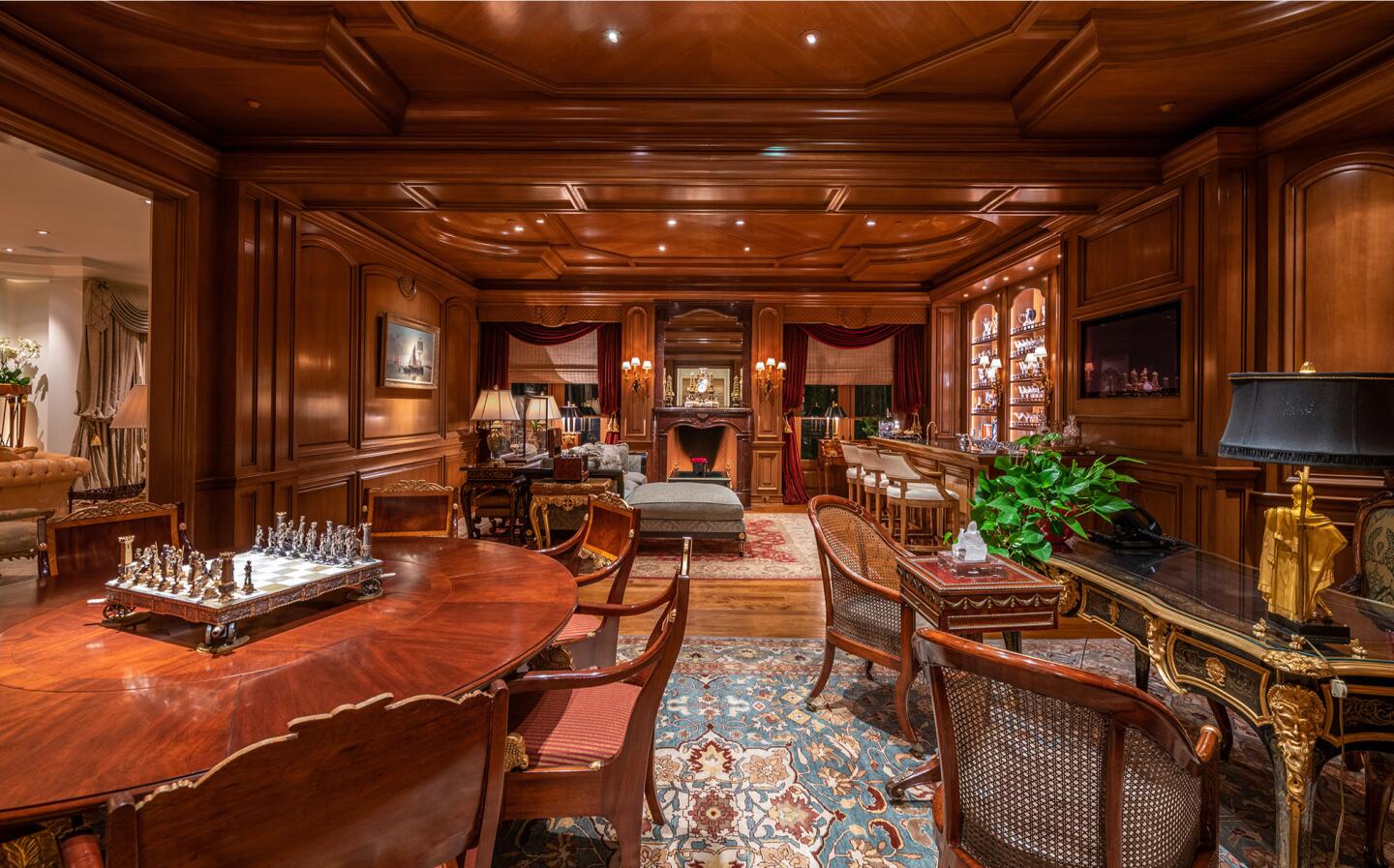 The wood paneled library with tables and chairs.