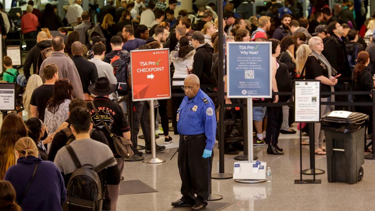 A TSA agent keeps an eye on travelers going through security at Los Angeles International Airport. The ACLU says documents it has obtained do not support the premise of the TSA behavior detection program.