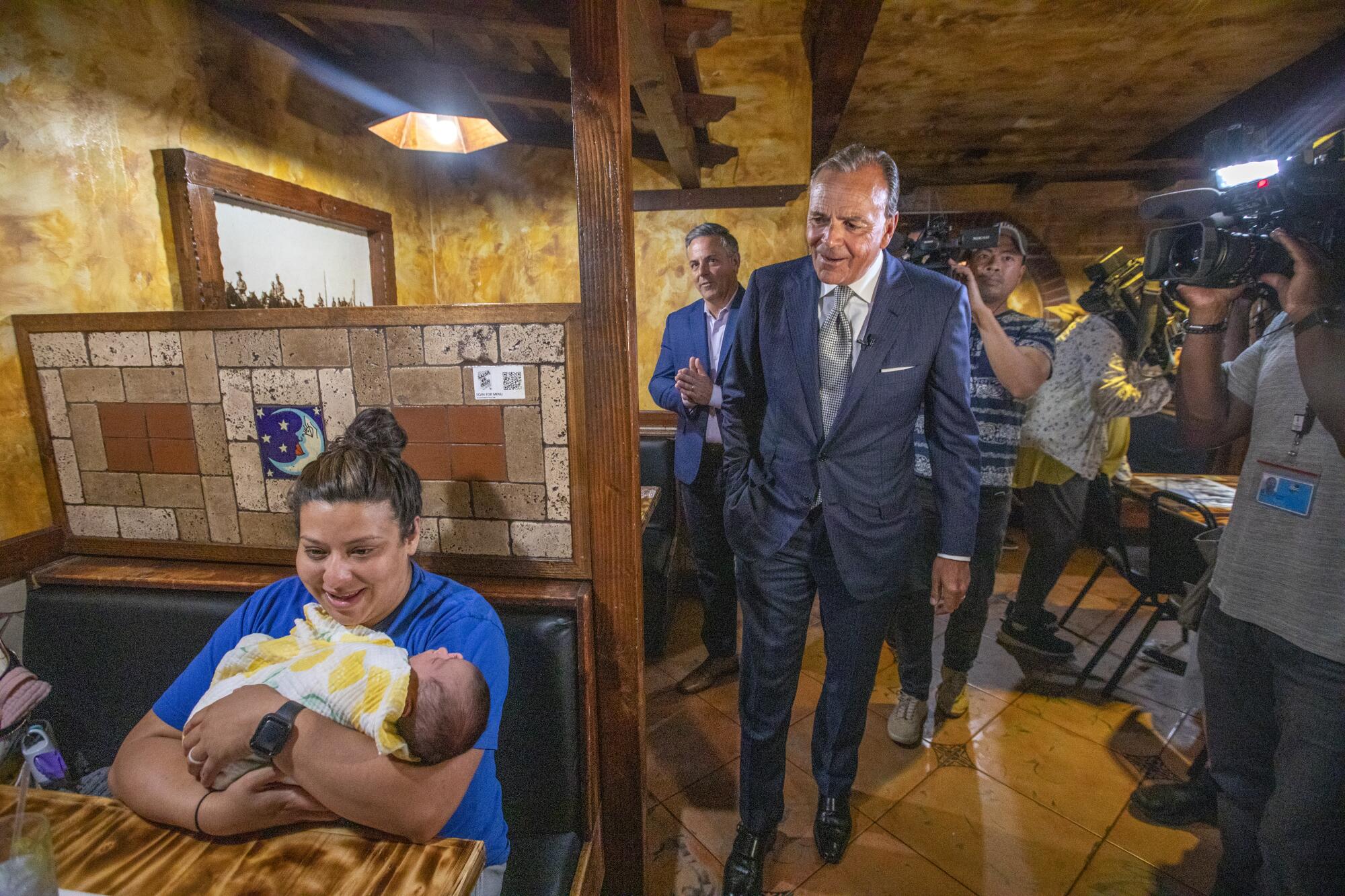 Rick Caruso visits Stephanie Quintero and her newborn, Natalia, at Salsa & Beer restaurant in North Hollywood.