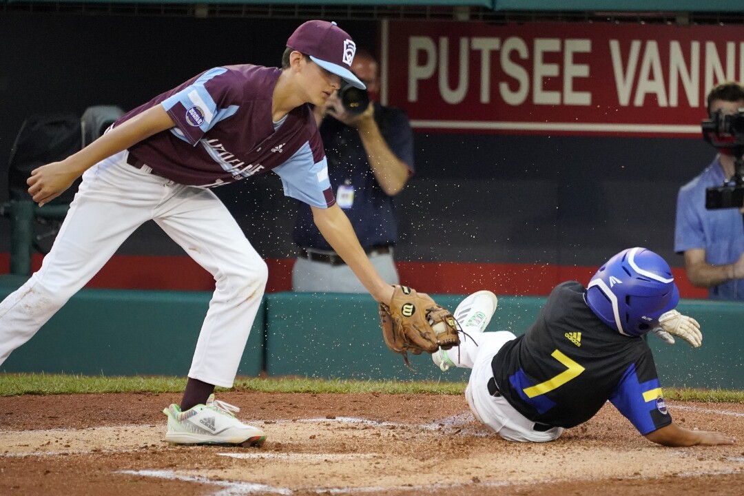 Hooksett, N.H., starting pitcher Mason DeVall, left, can't get the tag on Torrance, Calif.'s Xavier Navarro (7).