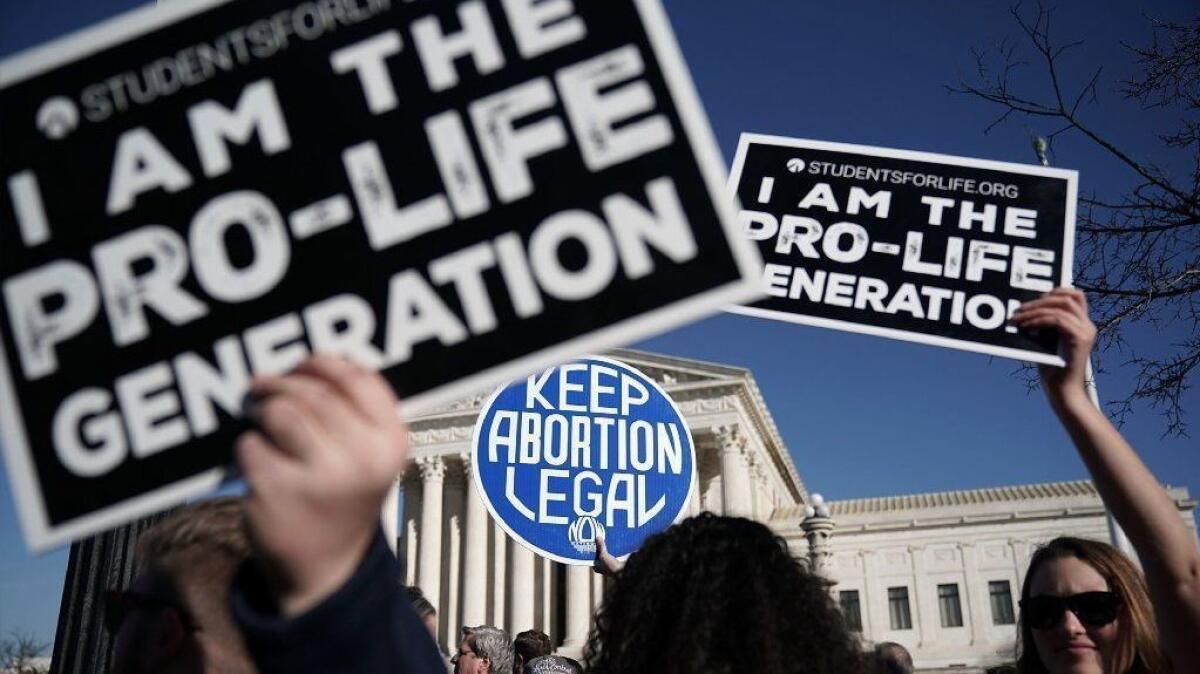Antiabortion activists try to block the sign of a pro-choice activist during the March for Life in Washington on Jan. 19, 2018.