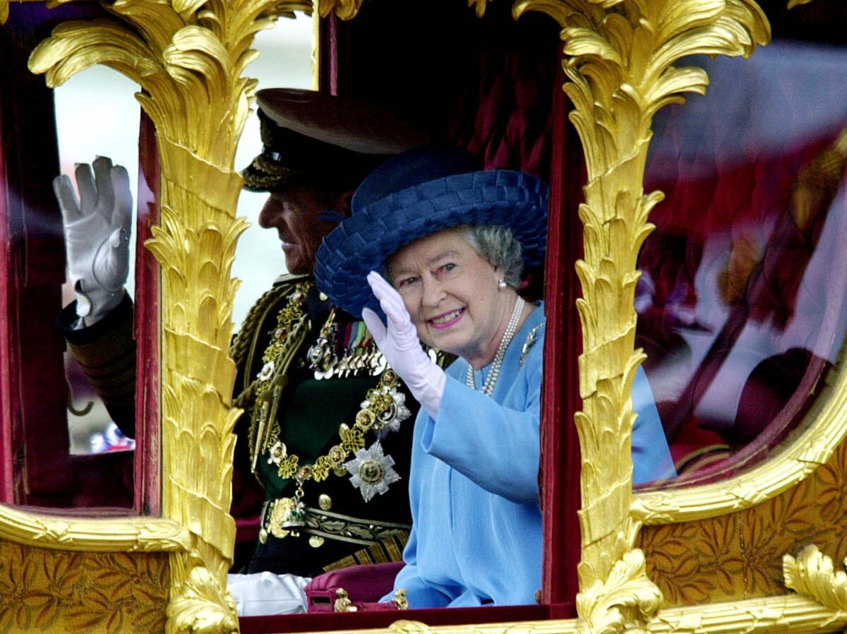 FILE - Britain's Queen Elizabeth II accompanied by her husband the Duke of Edinburgh wave to wellwishers as they ride Tuesday, June 4, 2002, in the State Gold Coach from Buckingham Palace to St Paul's Cathedral, in London for a service of thanksgiving to celebrate her Golden Jubilee. Queen Elizabeth II, Britain’s longest-reigning monarch and a rock of stability across much of a turbulent century, has died. She was 96. Buckingham Palace made the announcement in a statement on Thursday Sept. 8, 2022. (AP Photo/Rebecca Naden/Pool, File)