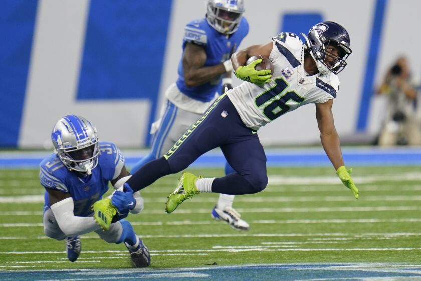 Seattle Seahawks wide receiver Tyler Lockett (16) is stopped by Detroit Lions safety Kerby Joseph (31) during the second half of an NFL football game, Sunday, Oct. 2, 2022, in Detroit. (AP Photo/Paul Sancya)