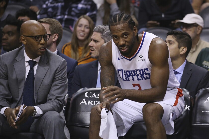 Clippers assistant coach Sam Cassell sits with Kawhi Leonard during a loss to the Suns on Oct. 26, 2019, in Phoenix. 