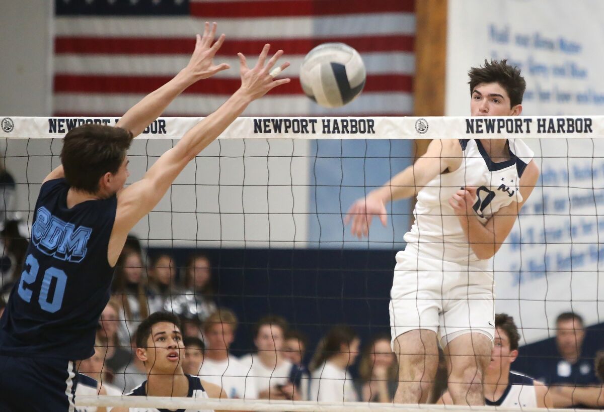 Newport Harbor High's Caden Garrido, right, puts the ball past Corona del Mar's Adam Flood (20) for a point in the Battle of the Bay rivalry on Friday at Newport Harbor.