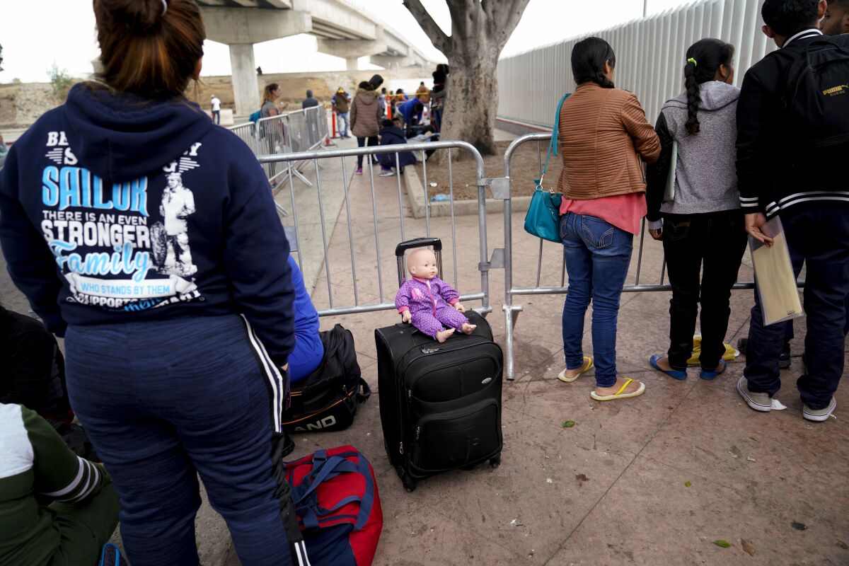 Asylum seekers wait to hear numbers called at El Chaparral