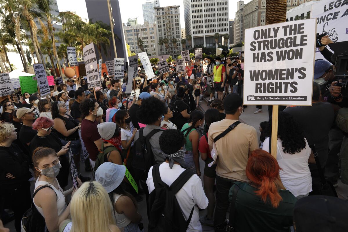 Demonstrators holding signs in Pershing Square in Los Angeles