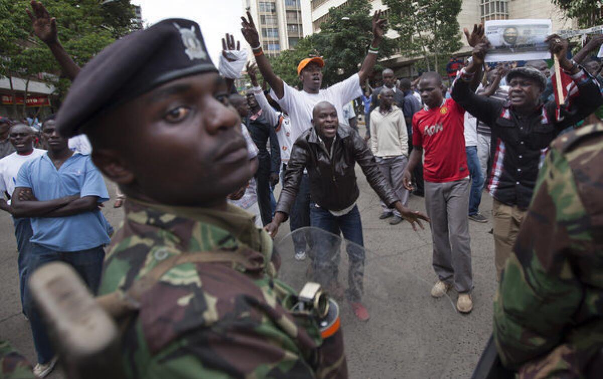 Supporters of losing presidential candidate Raila Odinga protest Saturday in front of riot police guarding the Supreme Court in Nairobi, Kenya.
