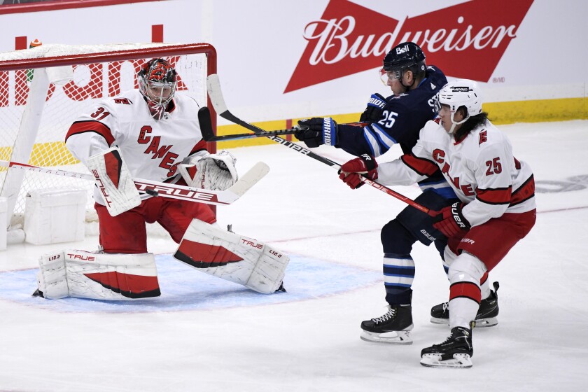 Carolina Hurricanes goaltender Frederik Andersen (31) makes a save on Winnipeg Jets' Paul Stastny (25) during the first period of an NHL game in Winnipeg, Manitoba, Tuesday, Dec. 7, 2021. (Fred Greenslade/The Canadian Press via AP)