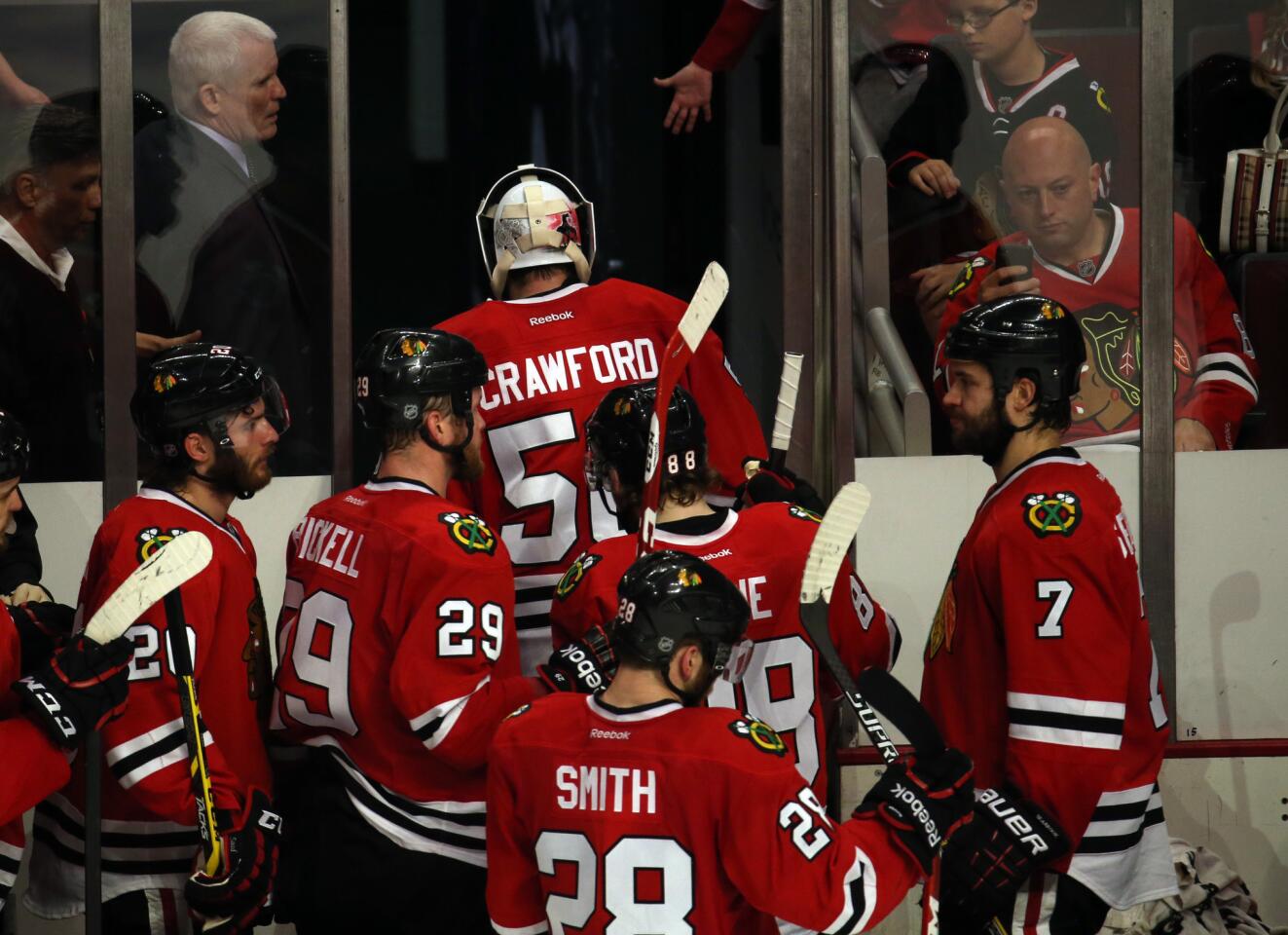 Blackhawks goalie Corey Crawford and teammates head to the locker room after the 6-2 loss.
