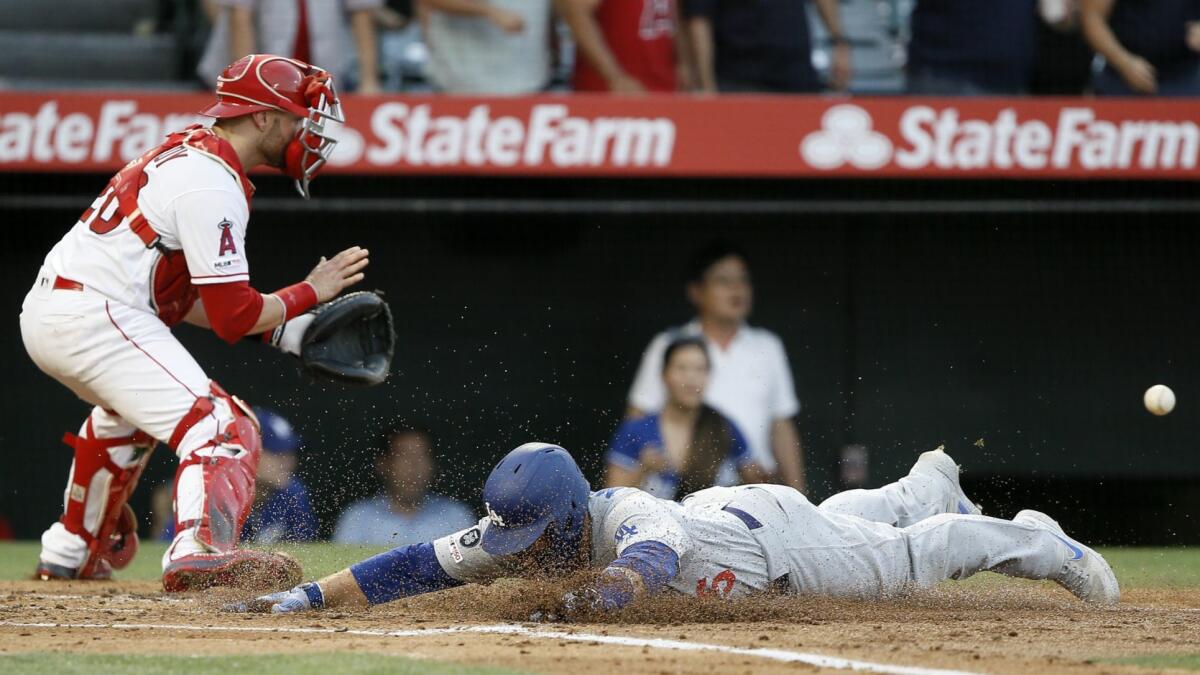 Dodgers' Russell Martin beats the throw to Angels catcher Jonathan Lucroy during the second inning Monday in Anaheim.