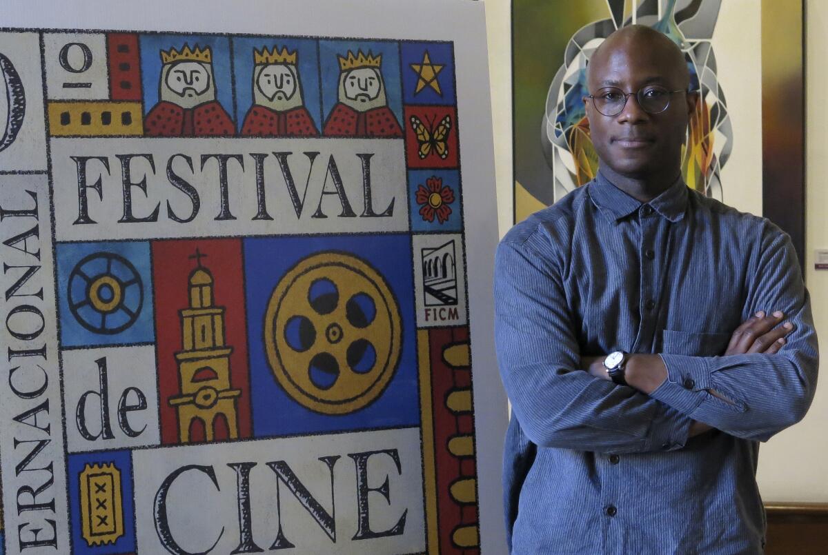 El cineasta estadounidense Barry Jenkins posa junto a un afiche del Festival Internacional de Cine