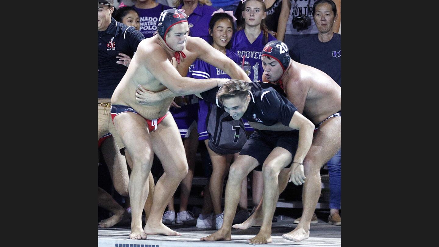 Burroughs' head coach Jacob Cook is grabbed by Burroughs' Sean Keane and Burroughs' Brenner Goldsen who have to battle him to throw him into the pool after defeating Hoover in the Pacific League boys' water polo finals at Arcadia High School on Thursday, October 26, 2017. Burroughs won their first title since 1994.